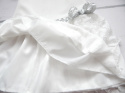 Elegancka sukienka ecrue z pionowymi falbankami i srebrnym paskiem